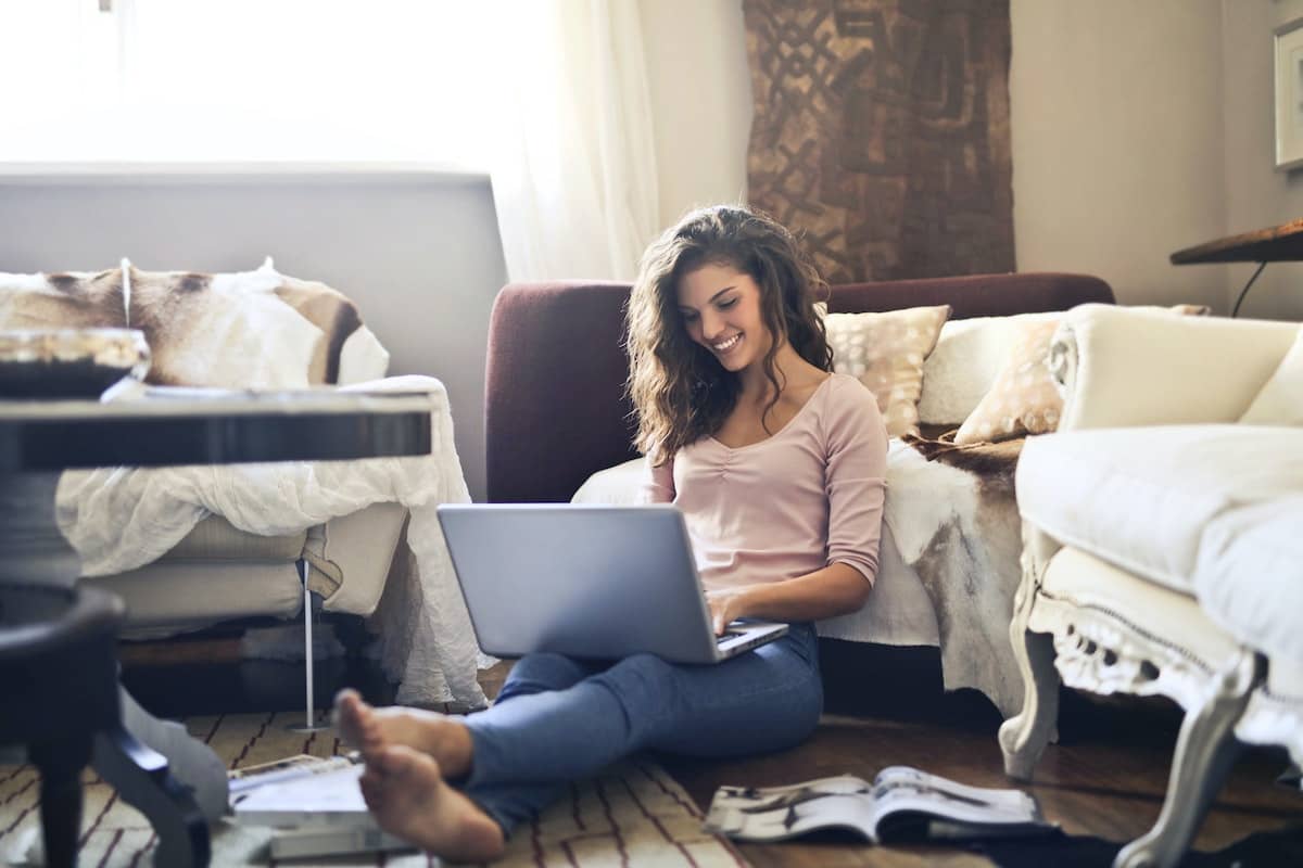 Woman smiling while using laptop working from home
